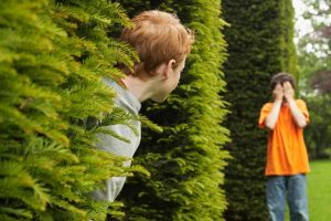 two-boys-playing-hide-and-seek-outside-136382522283403901-130815131633